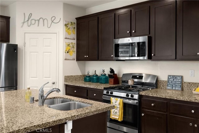 4337 Rima Dr, Fontana, CA 92336 - kitchen with stainless steel appliances, a sink, dark brown cabinets, and light stone countertops