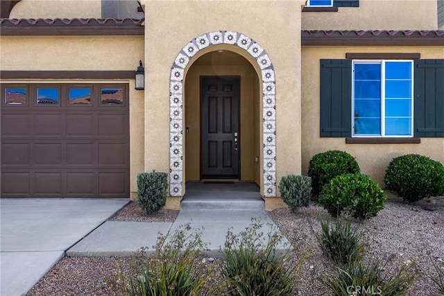 4337 Rima Dr, Fontana, CA 92336 - doorway to property featuring stucco siding, a garage, and concrete driveway