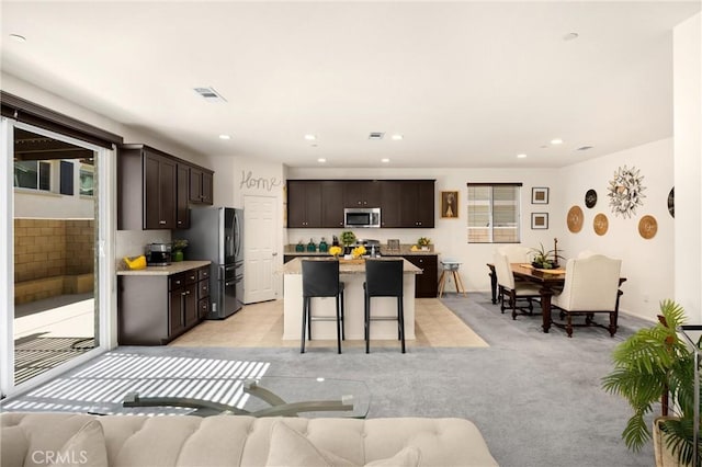 4337 Rima Dr, Fontana, CA 92336 - kitchen with appliances with stainless steel finishes, dark brown cabinetry, a kitchen breakfast bar, open floor plan, and recessed lighting