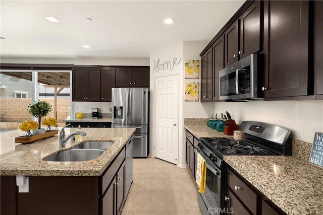 4337 Rima Dr, Fontana, CA 92336 - kitchen featuring appliances with stainless steel finishes, a sink, dark brown cabinets, light stone countertops, and recessed lighting