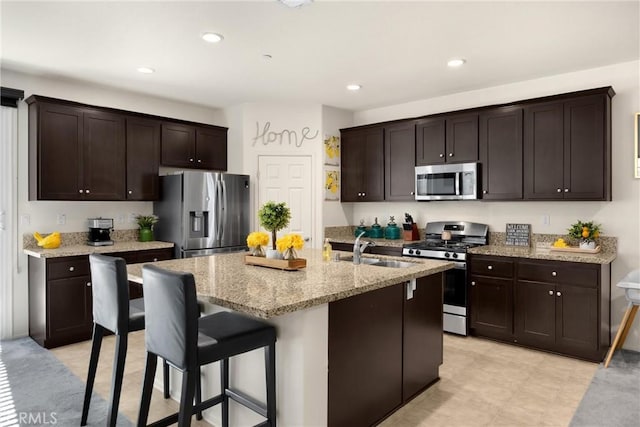 4337 Rima Dr, Fontana, CA 92336 - kitchen with stainless steel appliances, a sink, dark brown cabinetry, light stone countertops, and recessed lighting
