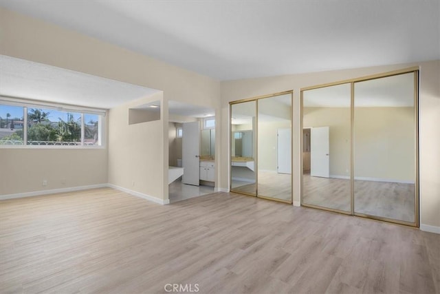 19924 Mildred Ave, Torrance, CA 90503 - unfurnished bedroom with two closets, wood finished floors, baseboards, and connected bathroom
