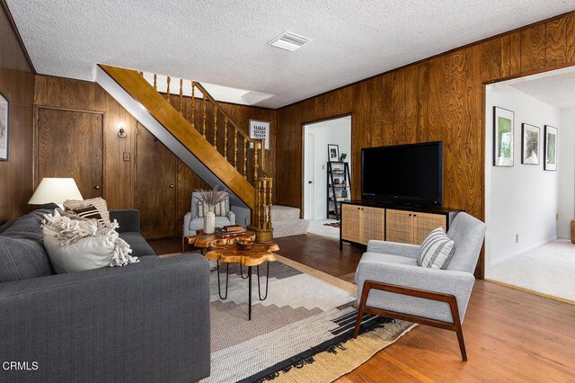1875 Rose Ave, San Marino, CA 91108 - living area featuring wooden walls, stairs, a textured ceiling, and wood finished floors
