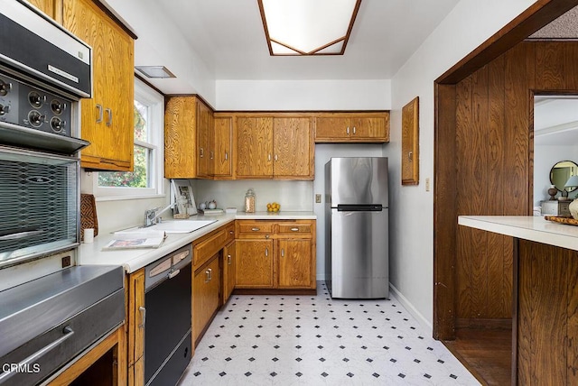 1875 Rose Ave, San Marino, CA 91108 - kitchen featuring freestanding refrigerator, black dishwasher, a sink, and brown cabinetry
