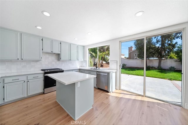 44779 Corte Sanchez, Temecula, CA 92592 - kitchen with appliances with stainless steel finishes, light countertops, light wood-style flooring, decorative backsplash, and a center island