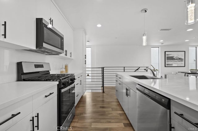 41361/2 Normal Ave Unit 1/2, Los Angeles, CA 90029 - kitchen featuring stainless steel appliances, a sink, light countertops, dark wood-style flooring, and recessed lighting
