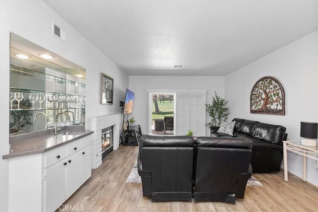 491 Desert Falls Dr N, Palm Desert, CA 92211 - living room with a glass covered fireplace and light wood-style flooring