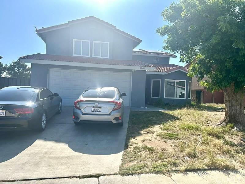 43708 Emile Zola St, Lancaster, CA 93535 - traditional-style house featuring driveway, stucco siding, a tile roof, and a garage