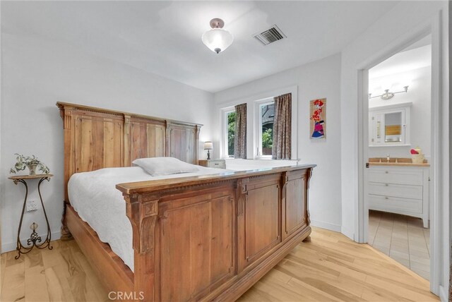 319 W 6th St, Claremont, CA 91711 - bedroom with light wood finished floors, ensuite bath, baseboards, and a sink