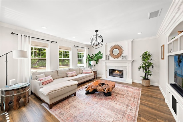 11 Markham Ln, Ladera Ranch, CA 92694 - living room with ornamental molding, dark wood-type flooring, a warm lit fireplace, a chandelier, and recessed lighting