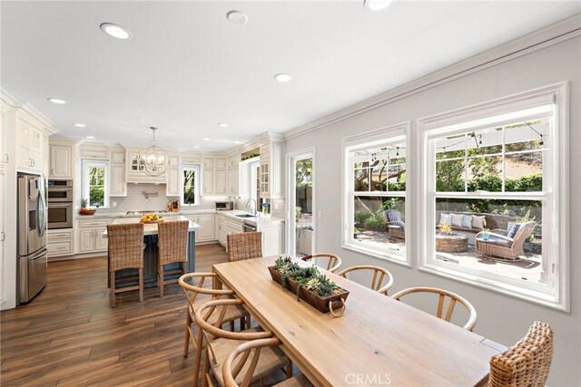 11 Markham Ln, Ladera Ranch, CA 92694 - dining room featuring healthy amount of natural light, a chandelier, dark wood-style floors, recessed lighting, and ornamental molding