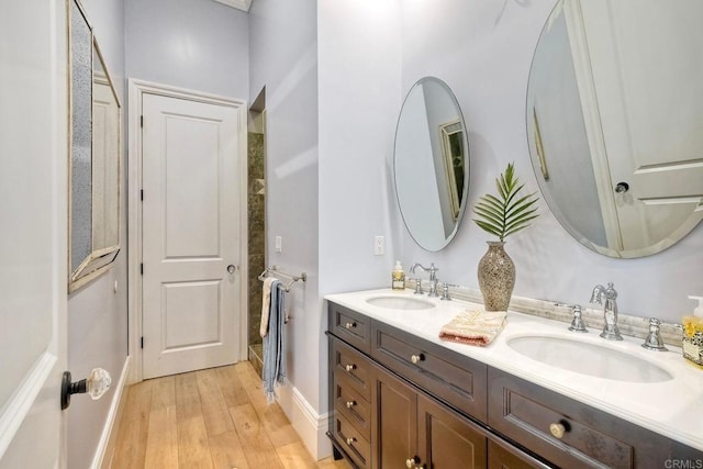 2507 Walinca Way, Vista, CA 92084 - bathroom with wood finished floors, double vanity, and baseboards