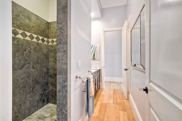 2507 Walinca Way, Vista, CA 92084 - full bathroom with a tile shower, wood finished floors, vanity, and baseboards