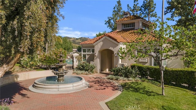 4240 Lost Hills Rd Unit 2102, Calabasas, CA 91301 - view of front of home featuring stucco siding, a tiled roof, and a front lawn