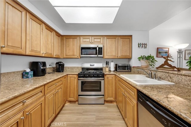 4240 Lost Hills Rd Unit 2102, Calabasas, CA 91301 - kitchen with stainless steel appliances, a sink, light wood finished floors, a skylight, and light stone countertops