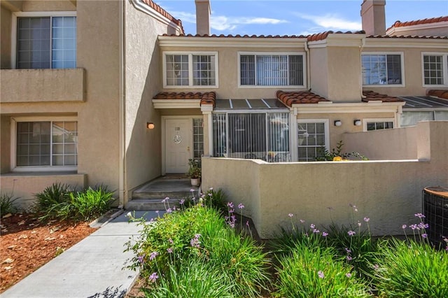 4240 Lost Hills Rd Unit 2102, Calabasas, CA 91301 - view of property with a chimney, stucco siding, a tiled roof, and cooling unit