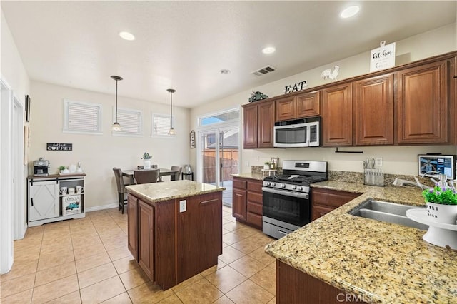 3116 Perdot Ave, Rosamond, CA 93560 - kitchen with appliances with stainless steel finishes, a sink, a kitchen island, pendant lighting, and light stone countertops