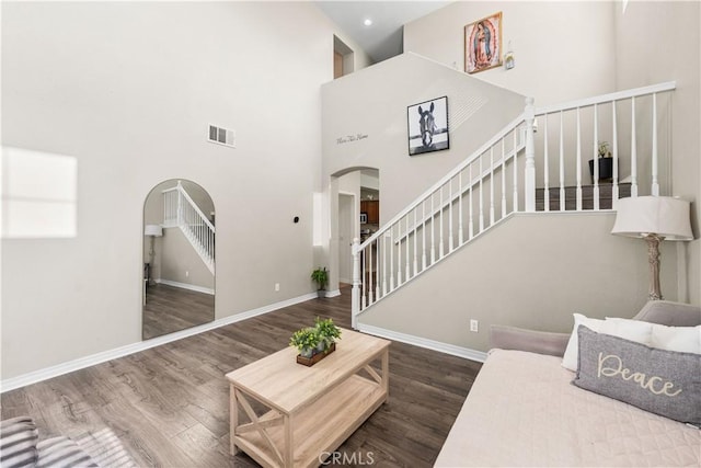 3116 Perdot Ave, Rosamond, CA 93560 - living room featuring arched walkways, wood finished floors, baseboards, and a high ceiling