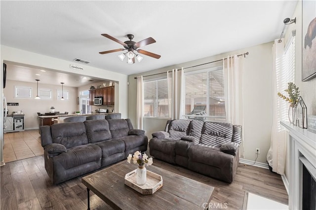 3116 Perdot Ave, Rosamond, CA 93560 - living room featuring ceiling fan, wood finished floors, healthy amount of natural light, and baseboards