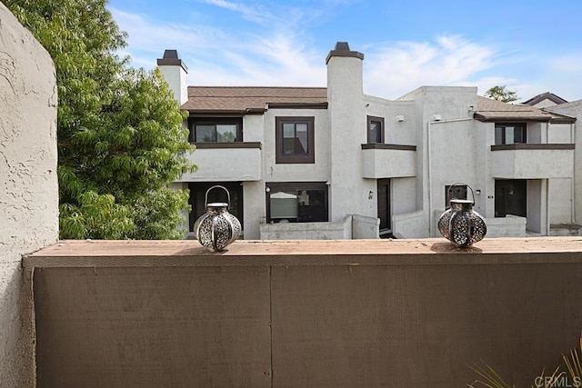 2284 Caminito Pajarito Unit 147, San Diego, CA 92107 - view of front of property featuring a chimney, a balcony, and stucco siding