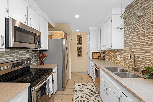 2284 Caminito Pajarito Unit 147, San Diego, CA 92107 - kitchen with appliances with stainless steel finishes, light tile patterned flooring, white cabinets, backsplash, and recessed lighting