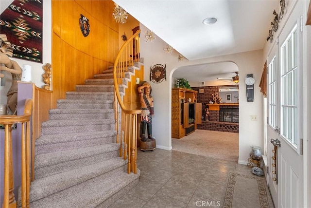1290 3rd, Calimesa, CA 92320 - tiled entryway with stairs, ceiling fan, arched walkways, baseboards, and a brick fireplace