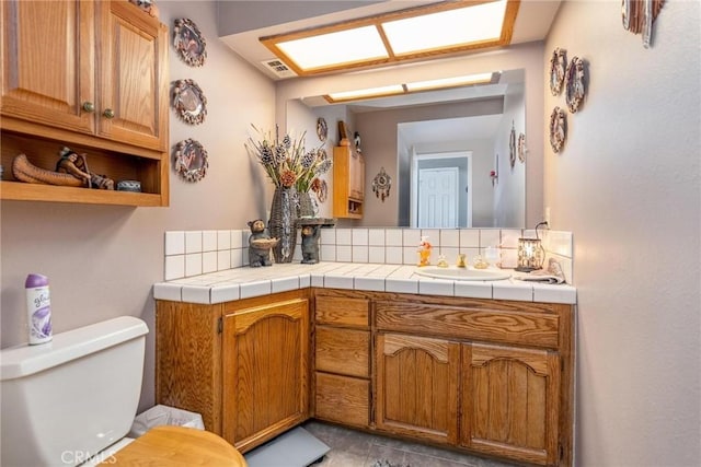 1290 3rd, Calimesa, CA 92320 - bathroom featuring toilet, vanity, and backsplash