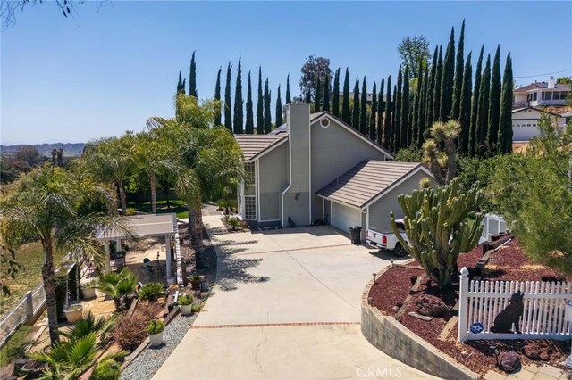 1290 3rd, Calimesa, CA 92320 - view of front of house with driveway, an attached garage, and a chimney