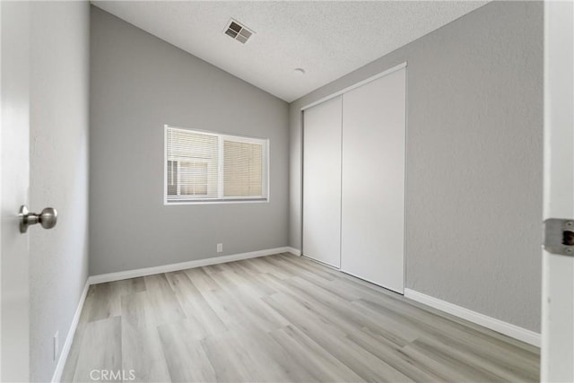 43638 Oleander St, Lancaster, CA 93535 - unfurnished bedroom featuring light wood finished floors, vaulted ceiling, a textured ceiling, a closet, and baseboards