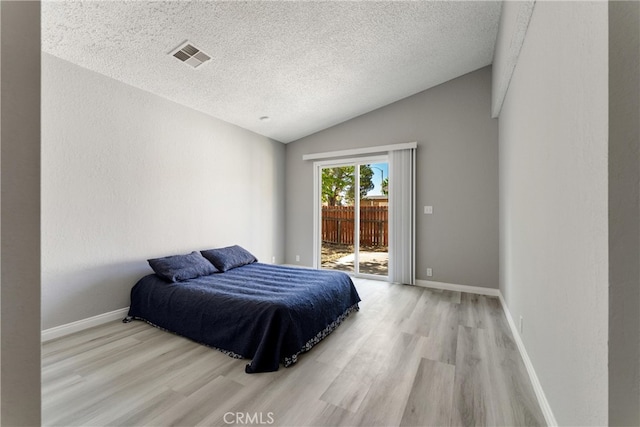 43638 Oleander St, Lancaster, CA 93535 - bedroom with access to outside, light wood-type flooring, vaulted ceiling, a textured ceiling, and baseboards