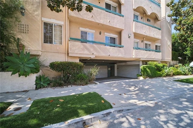 10659 Bloomfield St, Toluca Lake, CA 91602 - view of building exterior featuring an attached garage and concrete driveway