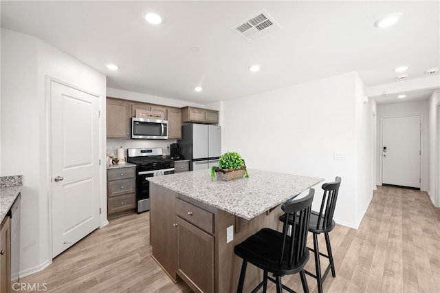 30769 Impala Ct, Winchester, CA 92596 - kitchen with stainless steel appliances, a breakfast bar area, a kitchen island, light wood-style floors, and recessed lighting