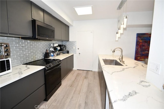 7309 Franklin Ave Unit 105, Los Angeles, CA 90046 - kitchen featuring black electric range oven, stainless steel microwave, a sink, white microwave, and light wood-style flooring