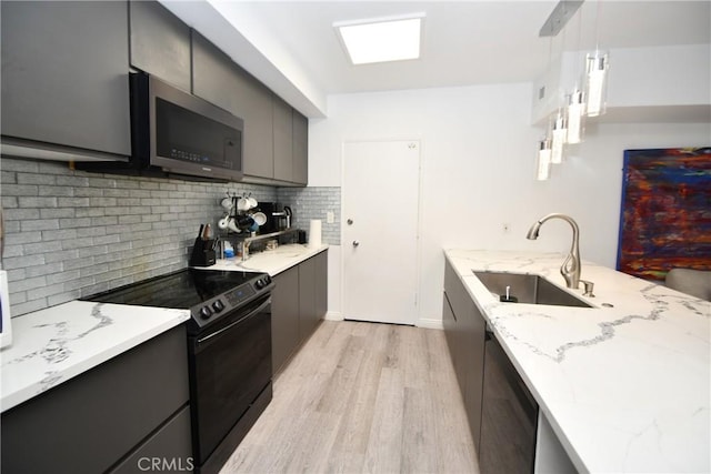 7309 Franklin Ave Unit 105, Los Angeles, CA 90046 - kitchen featuring black range with electric stovetop, a sink, stainless steel microwave, light wood-style floors, and modern cabinets