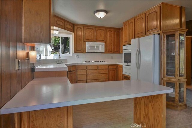 28680 Zion Dr, Lake Arrowhead, CA 92352 - kitchen featuring white appliances, light countertops, a peninsula, a warming drawer, and brown cabinets
