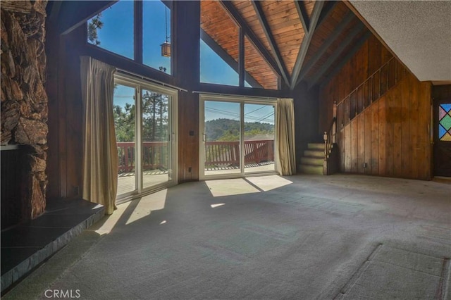 28680 Zion Dr, Lake Arrowhead, CA 92352 - unfurnished living room featuring carpet, wood walls, high vaulted ceiling, wooden ceiling with exposed beams, and stairs