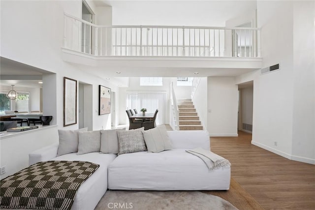 24775 Calle Serranona, Calabasas, CA 91302 - living room with stairs, a towering ceiling, wood finished floors, and baseboards