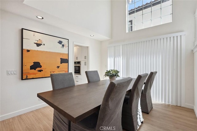 24775 Calle Serranona, Calabasas, CA 91302 - dining area featuring light wood-style floors, baseboards, a towering ceiling, and recessed lighting