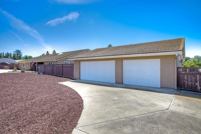 13815 Hilldale Rd, Valley Center, CA 92082 - view of side of home with a tile roof, stucco siding, a garage, and concrete driveway