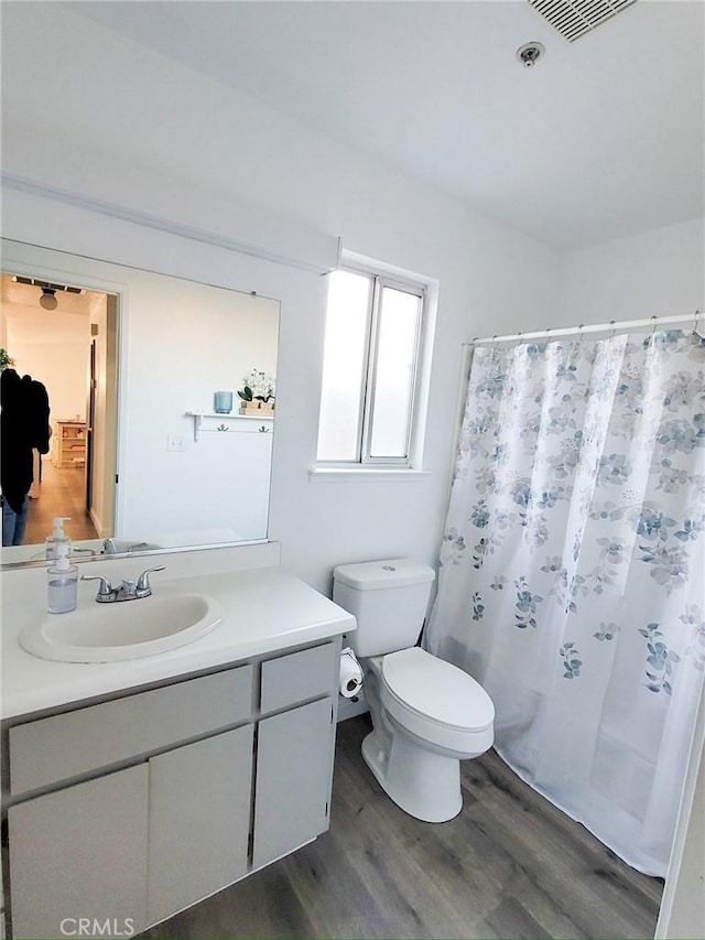 1485 Hansen Ave, Merced, CA 95340 - bathroom featuring wood finished floors, vanity, toilet, and curtained shower