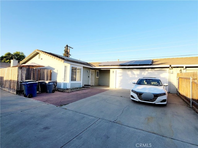 1485 Hansen Ave, Merced, CA 95340 - ranch-style house with driveway, a garage, and solar panels