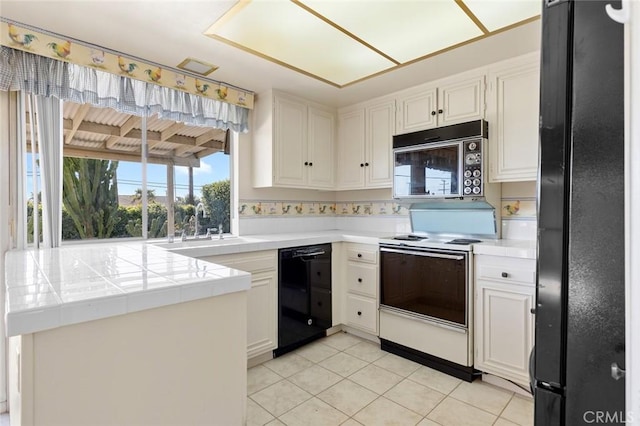 1713 Roanoke St, Placentia, CA 92870 - kitchen with black appliances, tile counters, light tile patterned flooring, a sink, and white cabinets