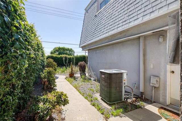 1713 Roanoke St, Placentia, CA 92870 - view of side of home featuring central AC, roof with shingles, mansard roof, and stucco siding