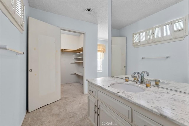 1713 Roanoke St, Placentia, CA 92870 - bathroom with vanity, a textured ceiling, and a spacious closet