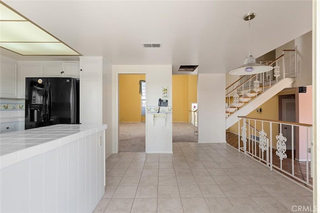 1713 Roanoke St, Placentia, CA 92870 - kitchen with black fridge with ice dispenser, tile counters, light tile patterned floors, white cabinets, and decorative light fixtures