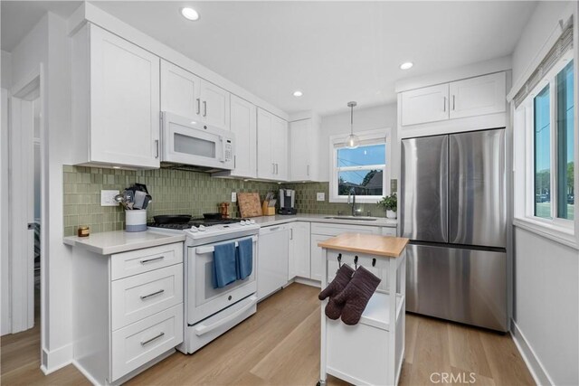 21322 S Western Ave, Torrance, CA 90501 - kitchen with white appliances, light countertops, decorative backsplash, light wood finished floors, and recessed lighting