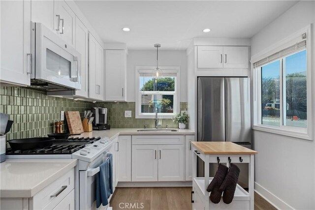21322 S Western Ave, Torrance, CA 90501 - kitchen featuring a sink, white microwave, gas range, light countertops, and white cabinetry