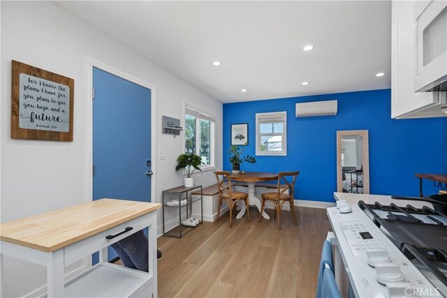 21322 S Western Ave, Torrance, CA 90501 - kitchen with a wall mounted air conditioner, light wood finished floors, white cabinetry, recessed lighting, and wood counters