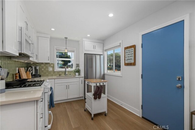 21322 S Western Ave, Torrance, CA 90501 - kitchen with a sink, gas range oven, white microwave, light countertops, and decorative backsplash