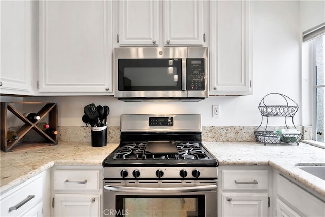 28747 La Triana, Laguna Niguel, CA 92677 - kitchen featuring appliances with stainless steel finishes, white cabinetry, and light stone countertops